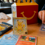 carte pokemon mcdo sur table avec booster et happy meal