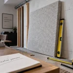 Fixation panneau acoustique : panneau feutre contre mur, repères et niveau